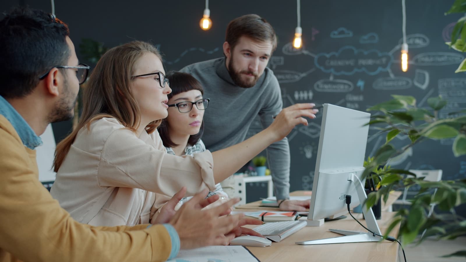 A team collaborating around a computer in an office